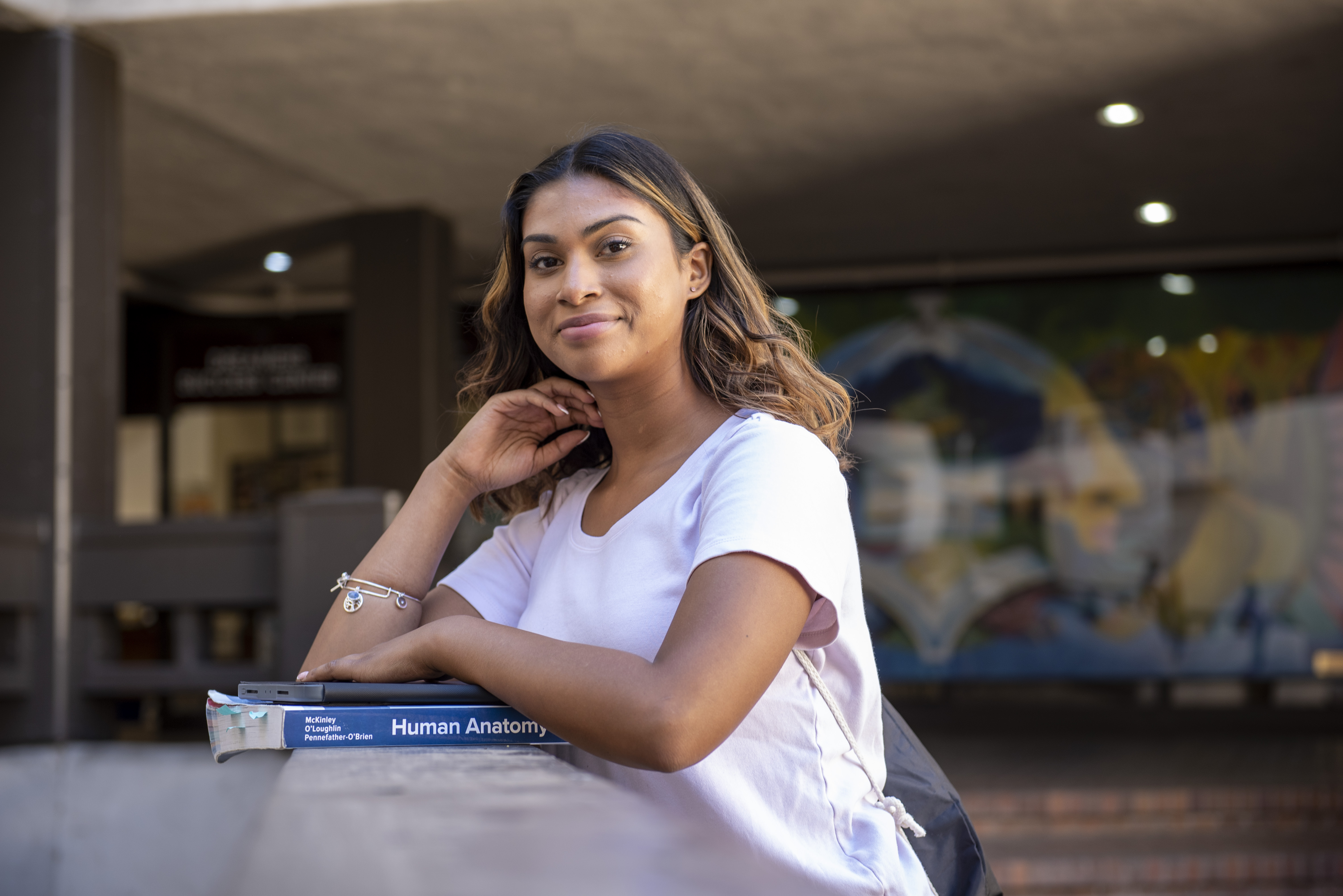 A Delta College student smiling with textbook