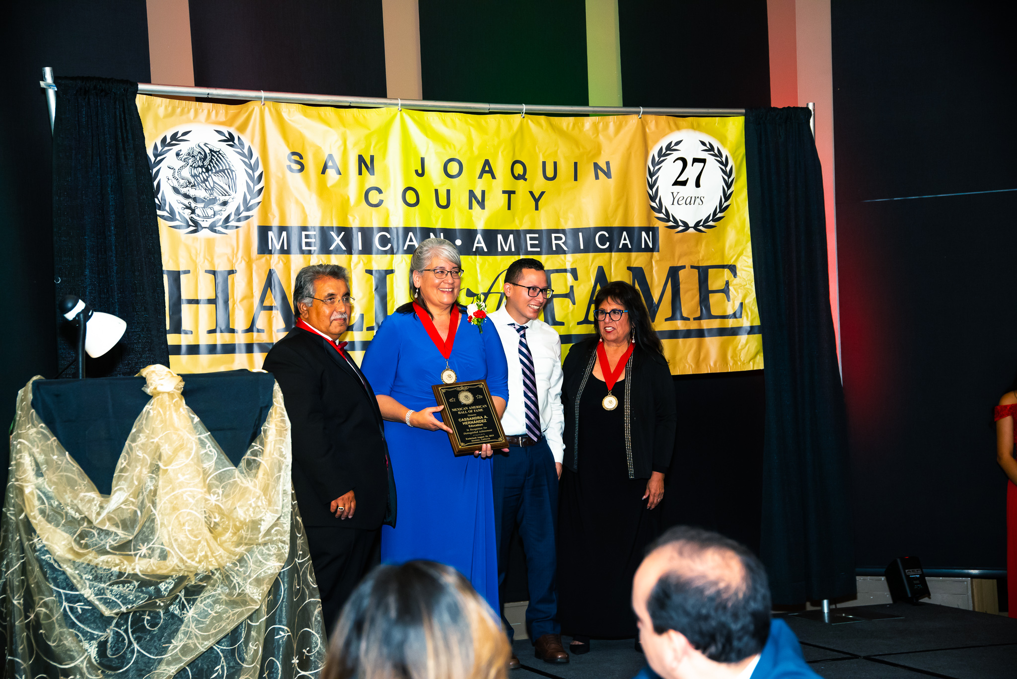 Cassandra Hernandez, second from left, is inducted into the San Joaquin County Mexican American Hall of Fame. Delta College Trustee Janet Rivera, far right, looks on.