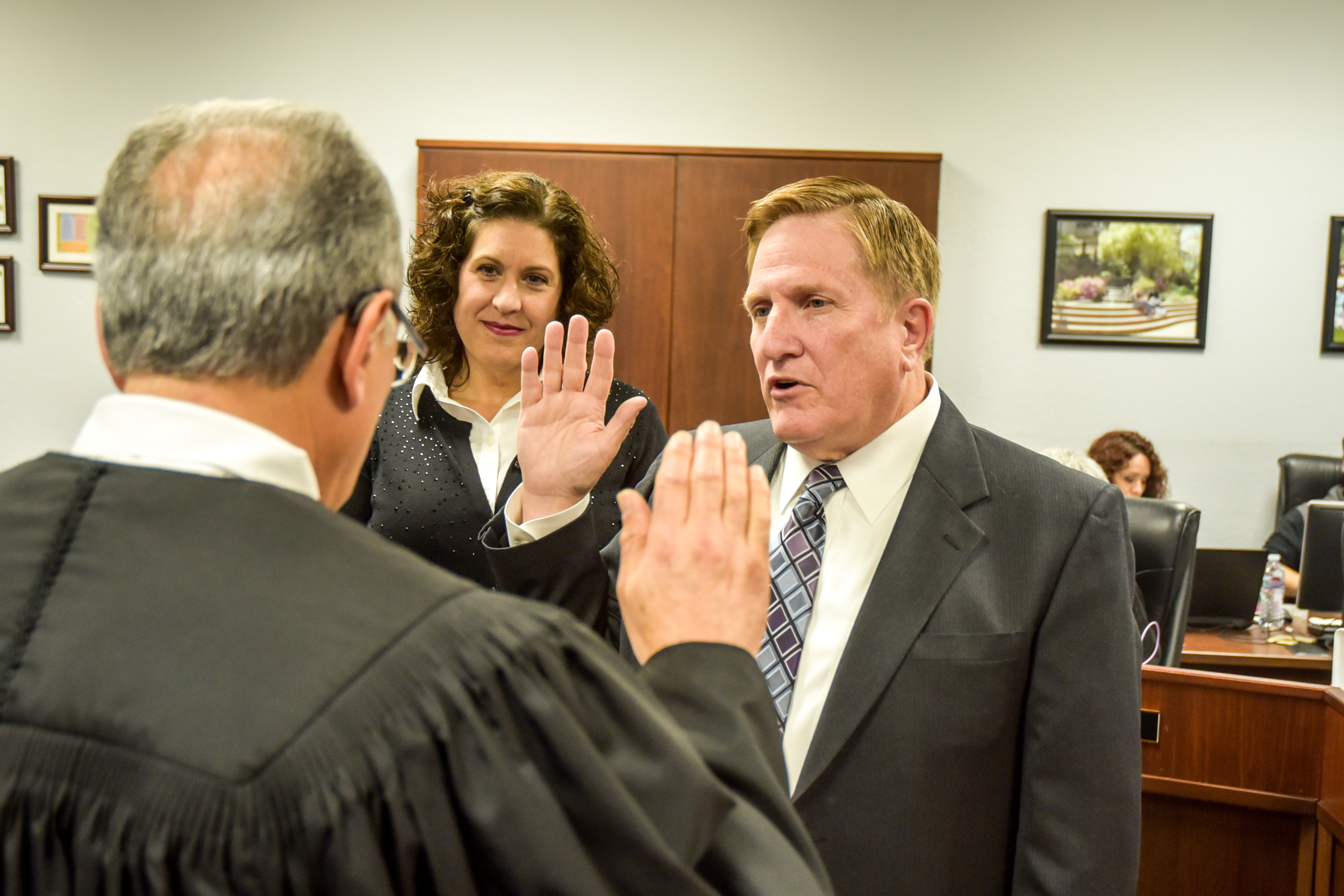 New San Joaquin Delta College Trustee Charles Jennings is sworn in while his wife, Heather, watches.