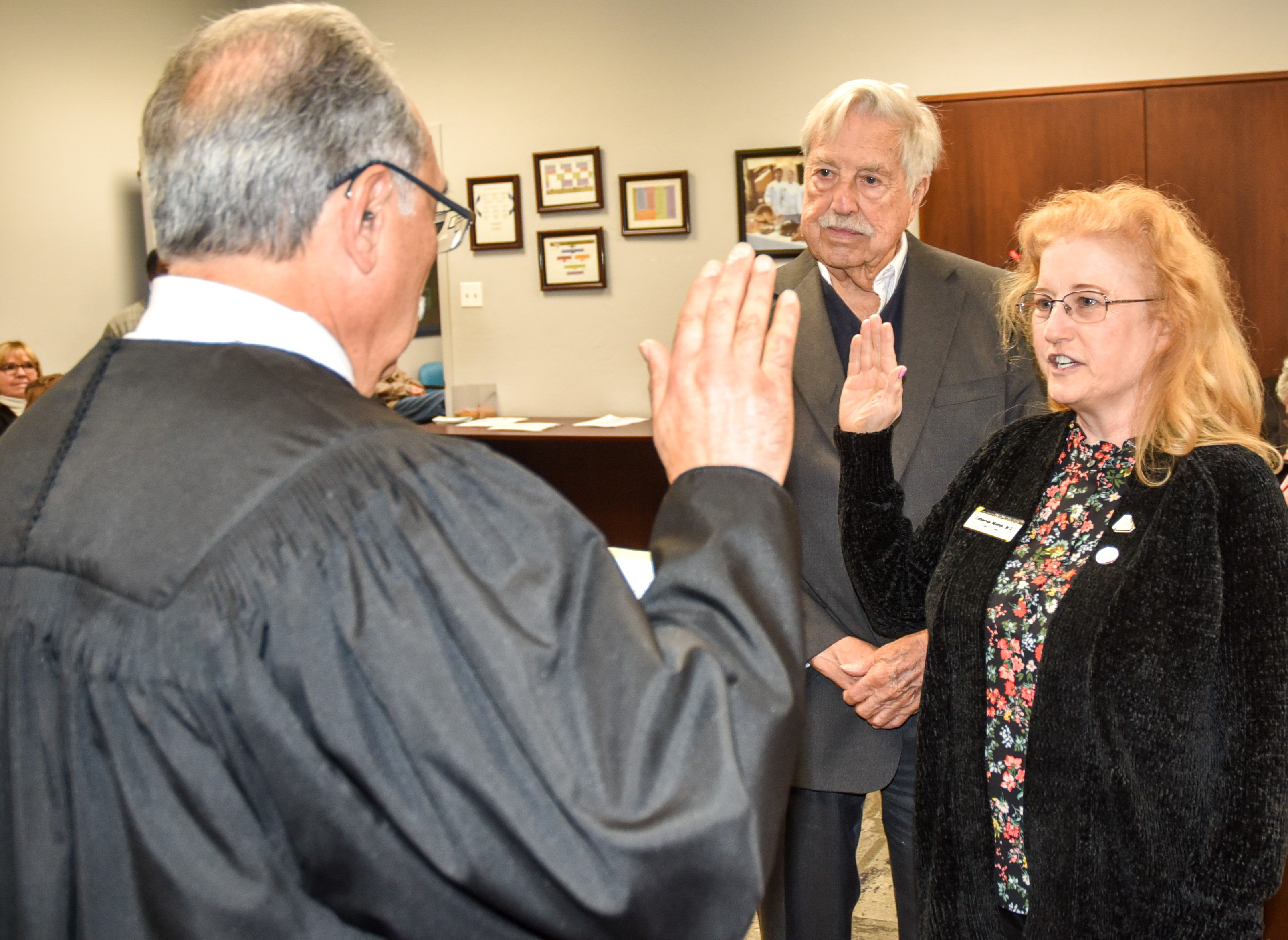 Returning San Joaquin Delta College Trustee Catherine Mathis is sworn in while her husband, Millard Frohock, watches.