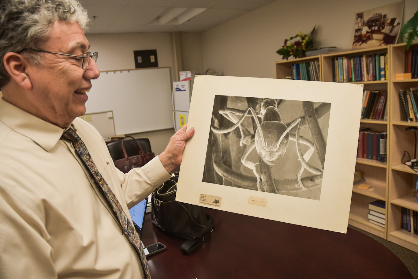 San Joaquin Delta College electron microscopy Professor Frank Villalovoz holds an image of an ant that was created by Thomas Deerinck when he was a student at Delta more than 40 years ago.