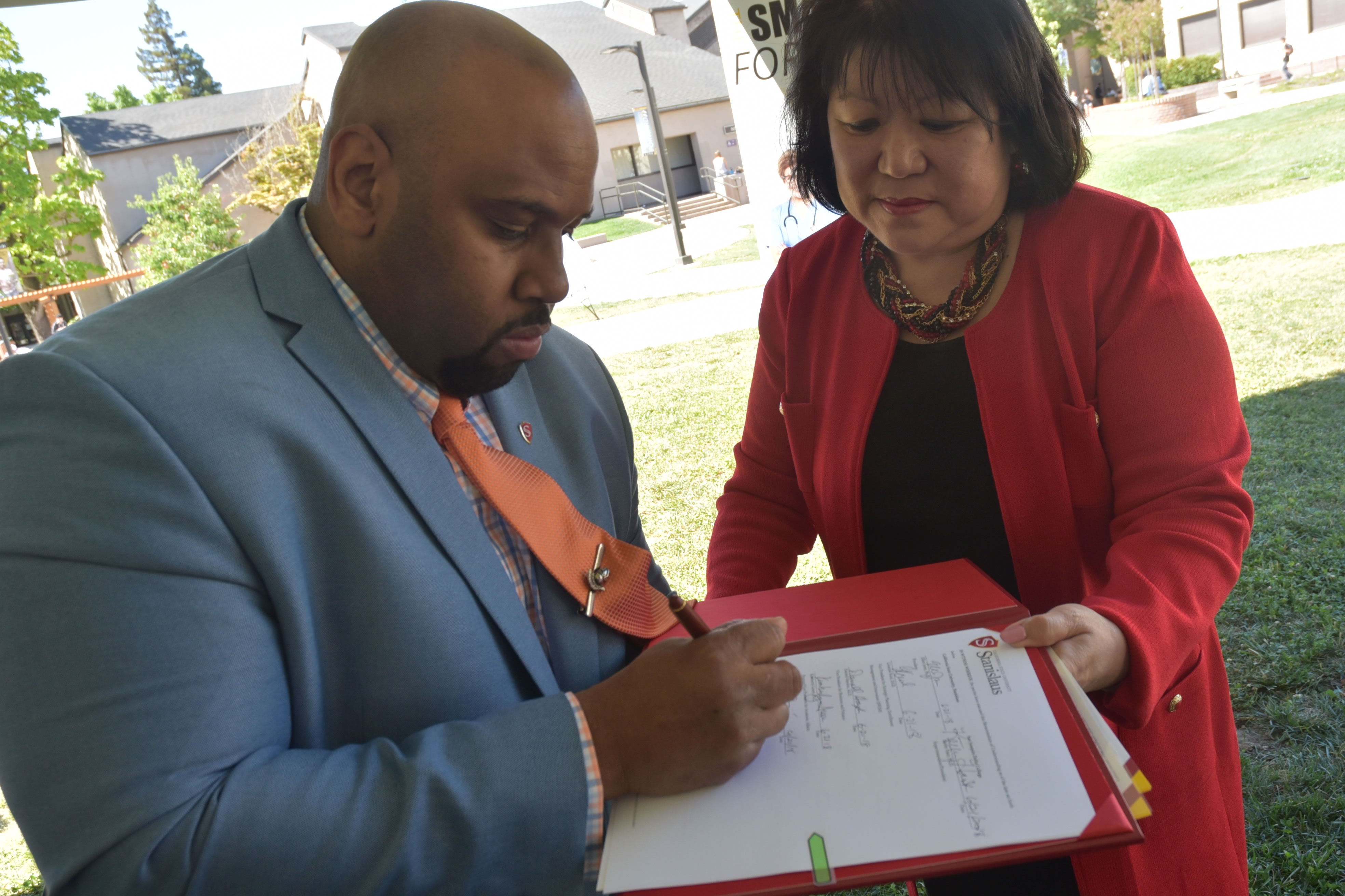 Faimous Harrison, dean of the Stanislaus State Stockton Center, signs the new agreement at San Joaquin Delta College on Thursday.