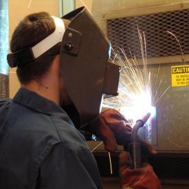 Student operates tools in welding class